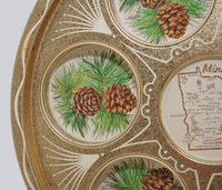 Shown is a close up of one of the indents for drinking glasses. Inside there are two pine cones and pine needles.