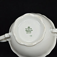 The backstamp is shown and has a crown, with the following underneath it: Marie Luise, Seltmann, Weiden, Germany and the number 95. All of that is green in color. There is some minor wear on the base of the Seltmann sugar bowl, consistent with the age. It was photographed on a black background.