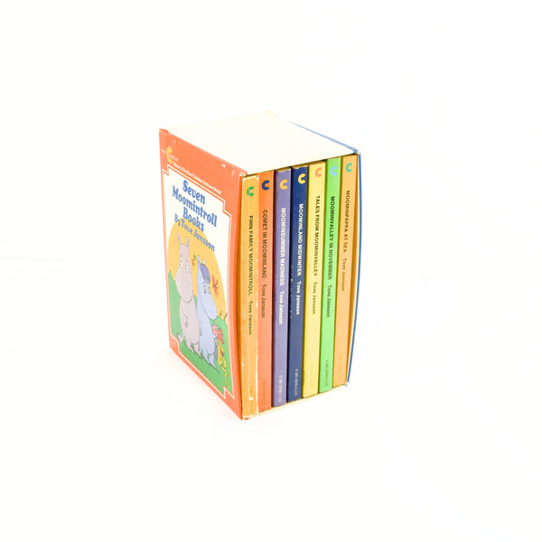 Shown are the boxed set of Seven Moomintroll Books by Tove Jansson. The seven books are paperback and each are a separate color. They are in a colorful cardboard sleeve.