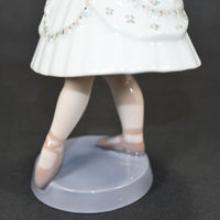 A closer view of the porcelain ballerina's legs and feet.