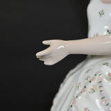 A close up of the porcelain ballerina's left hand.