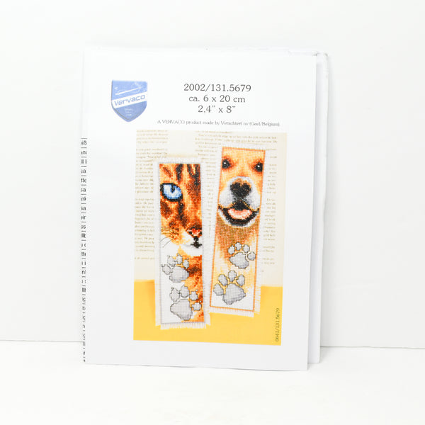 Shown is the front paper insert of the Vervaco by Verachtert cross stitch kit. Shown is a partial face of a cat bookmark and the partial face of a dog bookmark. Each animal is orange and brown in color with black highlights.