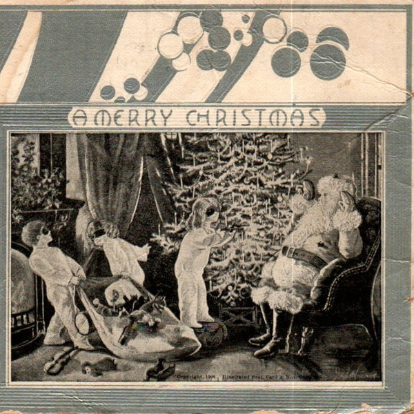 Shown is a partial view of the antique Merry Christmas postcard. Featured is a black and white illustration of Santa and three children, who are in masks. There is a beautiful Christmas tree in the background and a partial view of a fireplace on the left. Above the illustration are the words A merry Christmas.