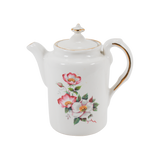 Featured is a vintage House of Webster teapot with the Wild Briar Rose pattern. The teapot was created prior to 1998. The teapot is white with gold trim on the edge of the handle and the top 'button' on the lid.