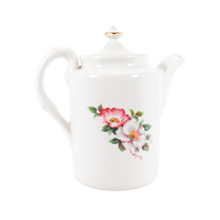 The backside view of the House of Webster teapot. The Wild Briar Rose pattern can be seen here also. The spout is facing to the right in the photo. The rim of the spout has gold trim on it.