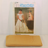 The factory folded tissue paper sewing pattern is shown laying in front of the paper envelope for Simplicity 6766.