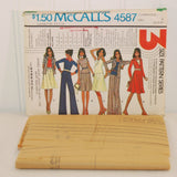 The factory folded tissue paper sewing pattern is shown laying in front of the paper envelope for McCall's 4587.