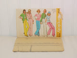 The factory folded tissue paper sewing pattern is laying in front of the paper envelope for Simplicity 5587.