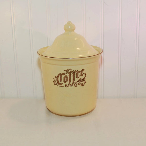 Featured is the vintage Pfaltzgraff pottery coffee canister. It is the Village pattern which is a creamy yellow with brown writing and design on the front. The canister comes with a lid.