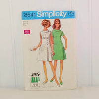 The front of the paper envelope for Simplicity 8541 circa 1969. There is an illustration of two women in above knee dresses. One dress is white and sleeveless and the other one is a light green color with a rounded collar.