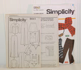 Shown is the paper instruction sheet for Simplicity 9841. There are 4 pages and the instructions are in English and Spanish 3. The instruction sheets are propped up and are slightly in front of the paper envelope for Simplicity 9841.