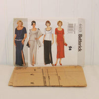 The factory folded tissue paper sewing pattern is laying in front of the upright paper envelope for Butterick 6413.