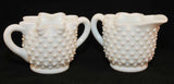 A closer view of the Fenton sugar and creamer set. The sugar has two milk glass handles and the creamer has one handle.