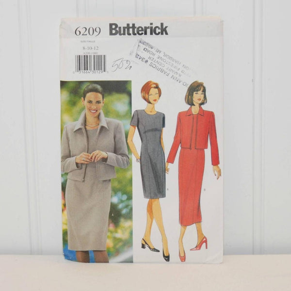 Shown is the front of the paper envelope for Butterick 6209. There is some writing and an ink stamp. On the left is a woman wearing clothes that were made from the pattern. There are two illustrated women also wearing examples of the clothes that can be made with this pattern.