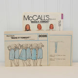 Shown is the instruction sheets for McCall's 8086 sewing pattern. There are two sheets and they are propped up in front of the paper envelope.