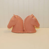 This is the side view of the two Abingdon pottery horse head bookends. They are sitting on a white background.