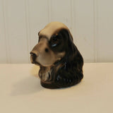 Shown is a Cocker Spaniel head bookend. It is possibly c. 1950's. It is made of plaster and is black and white in color. It is shown on a white background.