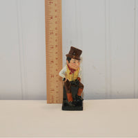 There is a wooden ruler to the left of the Sam Weller figurine, it is approximately 4 inches in height.