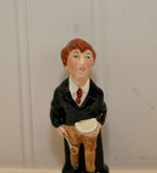 A close up of the Oliver Twist figurine. The figurine is in front of a white background.