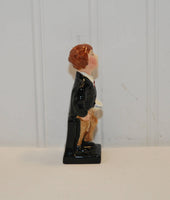 A side view of the Oliver Twist figurine by Royal Doulton.