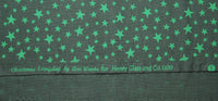 A close up of the selvidge that has Christmas Everyday by Ann Wanke for Henry Glass and Co. 1100 printed in green on it.