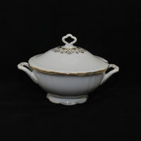 Featured is an elegantly beautiful piece of Seltmann fine china. It is a soup tureen that has a lid. It is the Marie Luise pattern that was made by Seltmann in Weiden Germany. The tureen is a creamy white with gold trim and decor. It has two handles on the body and a handle on the top of the lid.
