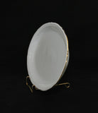 A side view of the platter, the gold band on the edge can also be seen. The platter is propped up on a plate stand.