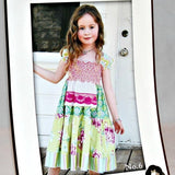 Shown is a partial view of the insert for The Lydia Dress No. 6. Shown is a young girl, standing in front of a door with the dress that can be made with this pattern.