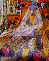 A page from the book that shows a photo of a beautiful quilts draped over a wood rocking chair.