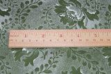 There is a wooden ruler on top of the fabric to show the pattern size.