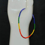 There is a 9 1/2 inch pride rainbow seed bead ankle bracelet shown on a vintage white ceramic hand.
