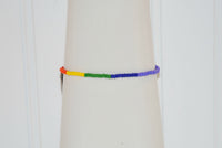 A side view of the Pride bracelet handcrafted by Too Hip Chicks. Orange, yellow, green, blue and purple seed beads can be seen.