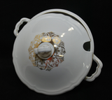 The Seltmann soup tureen lid is propped up to show the delicate gold pattern on top of the lid.